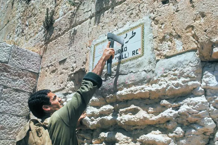 צנחן מנפץ את שלט "דרך אל-בוראק". צילום: מיכה בר-עם.