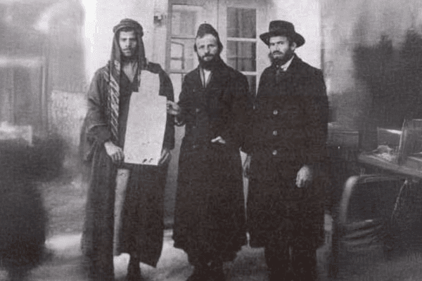 משפחת פרוש ר' משה פרוש מקבל את ה'קושאן' של אדמת "נחלת ישראל" מהמוכר הערבי. מימין – איש המעש והחזון רבי יוסף לוי חגיז. צילום: לא ידוע.