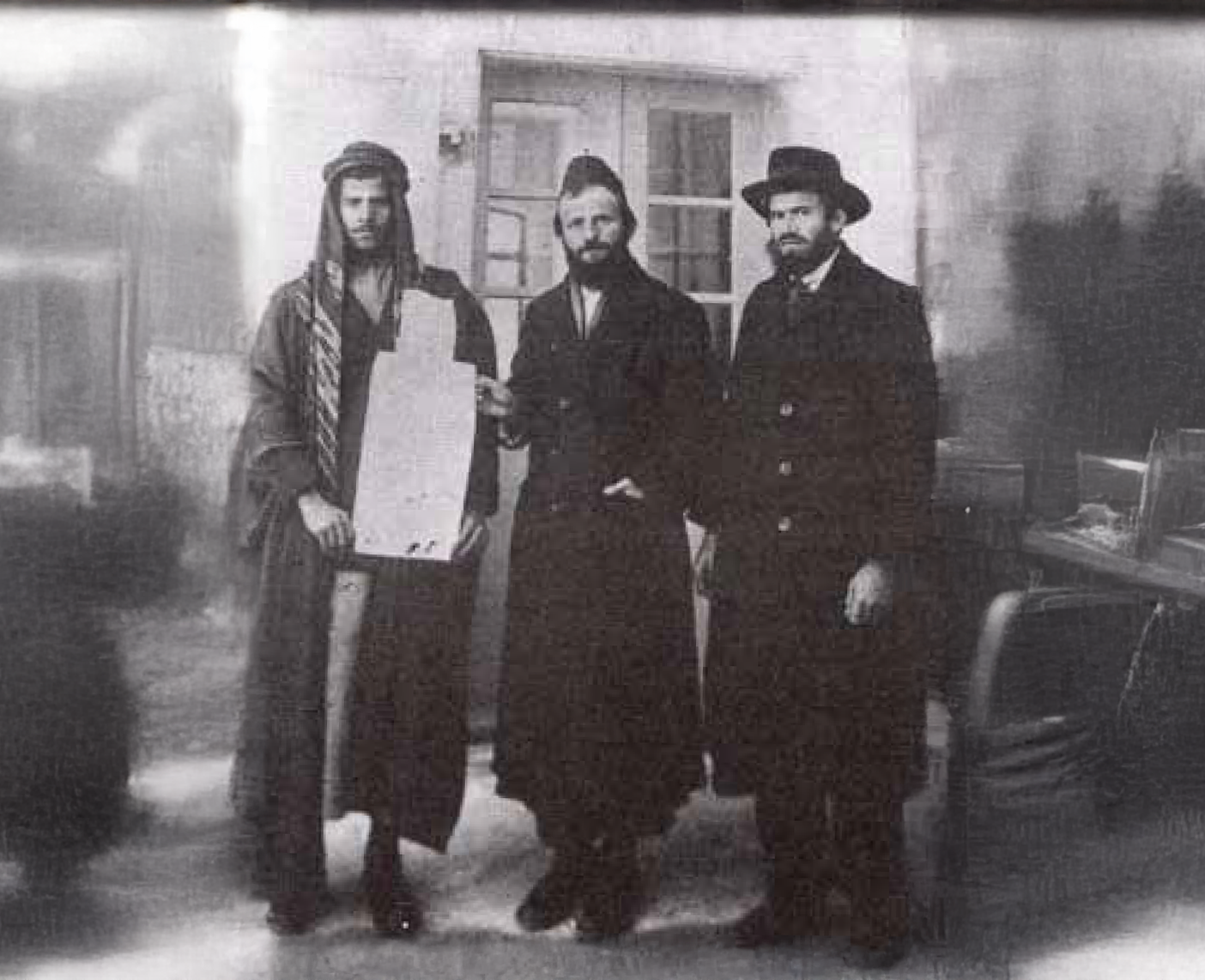 ר' משה פרוש מקבל את ה'קושאן' של אדמת "נחלת ישראל" מהמוכר הערבי. מימין – איש המעש והחזון רבי יוסף לוי חגיז. צילום: לא ידוע.