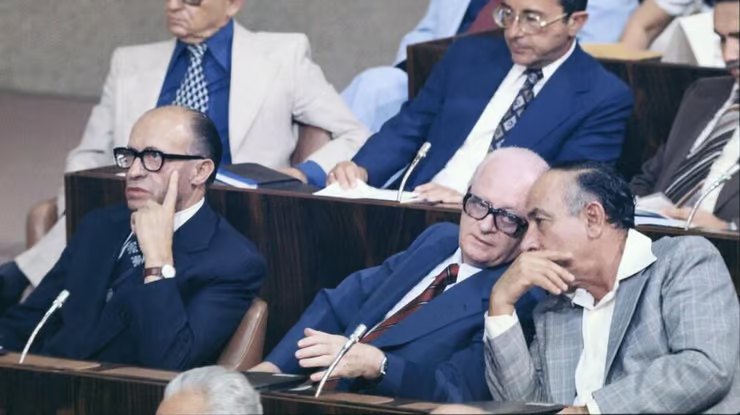 בגין במליאת הכנסת. משמאל מסתודדים שמחה ארליך ויגאל הורביץ. צילום: אלון ריינינגר.