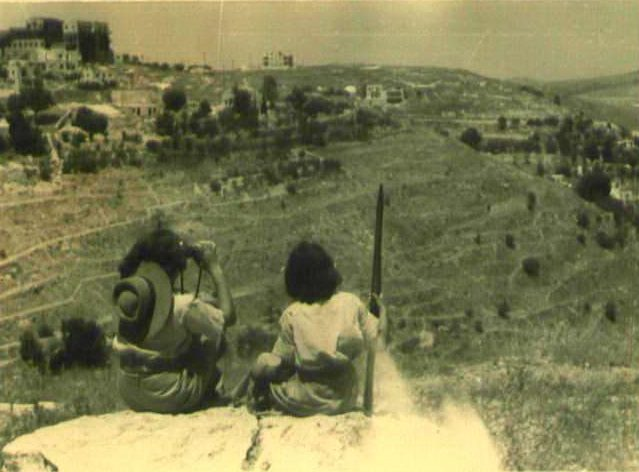 שתי לוחמות לח"י משקיפות על הדרך לירושלים. צילום: לא ידוע.