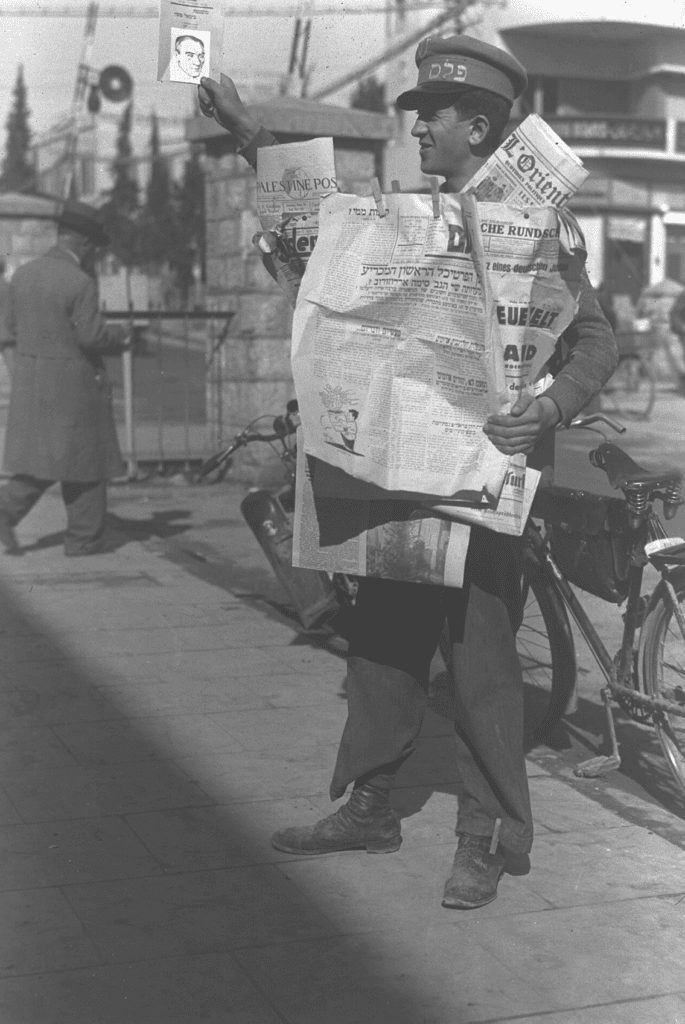 מוכר עיתונים מציג את הדף הראשון של חזית העם מ-8 בינואר 1934. צילום: זולטן קלוגר.