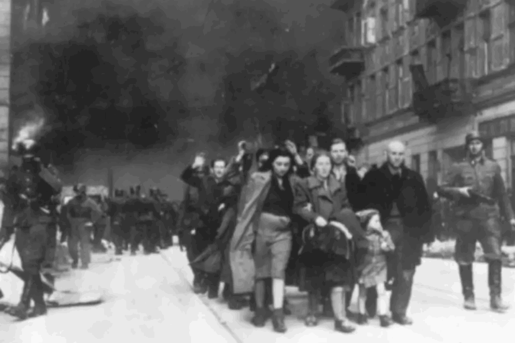 יהודים מובלים על ידי חייל הנאצי מתוך הגטו השרוף, לאחר הכניעה. תמונה זו לקוחה מתוך אלבומו הפרטי של שטרופ, מפקד הכוחות שפעלו לחיסול המרד בגטו ורשה. הכיתוב המקורי באלבום: "נשלפו מהבונקר בכוח".